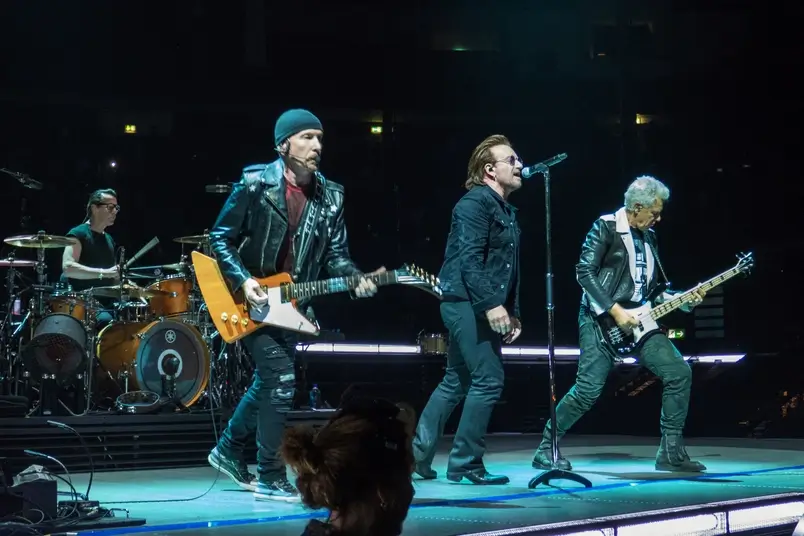 Uma foto da banda U2 tocando no palco.