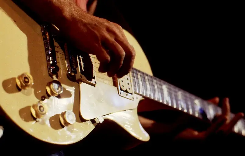 Um guitarrista tocando uma guitarra elétrica sem usar palheta