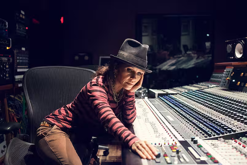 Linda Perry mexendo em uma mesa de som em um estúdio de música