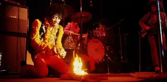 Jimi Hendrix colocando fogo em sua guitarra em uma apresentação histórica