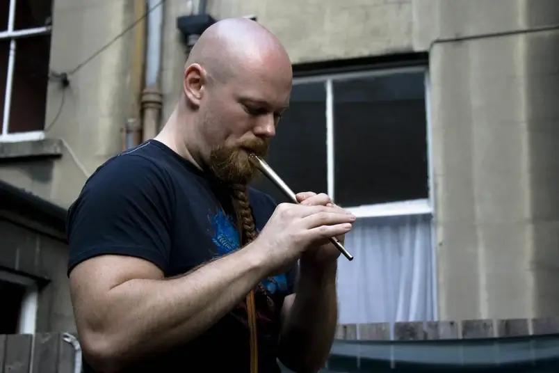 Um homem tocando um tin whistle